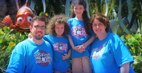 A family wearing Hidden Mickey Society shirts